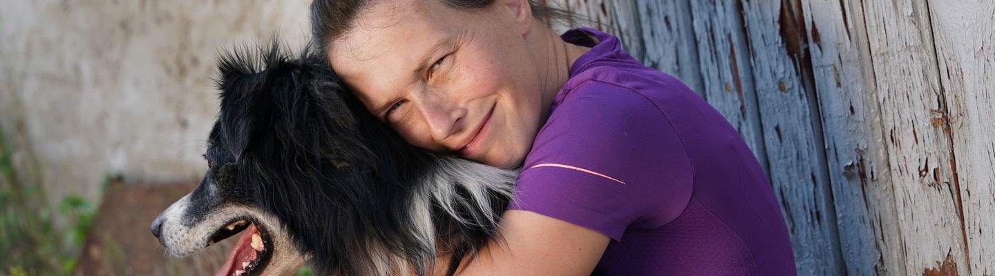 Mitarbeiterin des Allgemeinen Tierhilfsdienstes knuddelt einen Border Collie