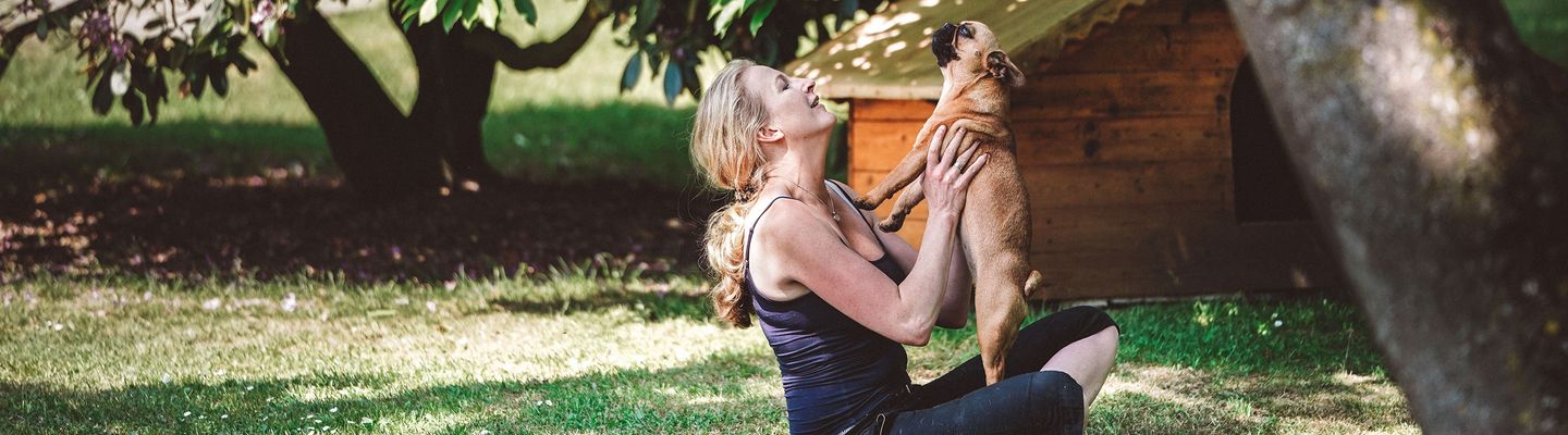 Iris Volk hält einen Hund hoch